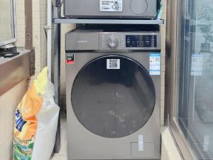 a washing machine with a microwave on top of it at 泊金青年旅舍-深圳北站店 in Shenzhen
