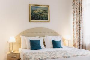 a bedroom with a bed with blue and white pillows at Hotel N in Belgrade +123 photos