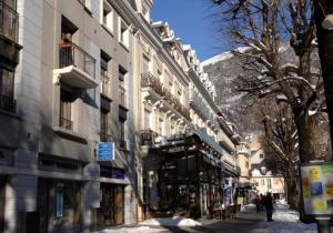 a city street with buildings and snow on the ground at Vacancéole - Résidence Illixon in Luchon