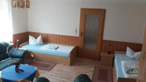 a room with two beds and a couch and a mirror at Pension Partzsch in Siebenlehn