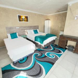 two beds in a room with a carpet at Godmill guesthouse Taung in Lethola