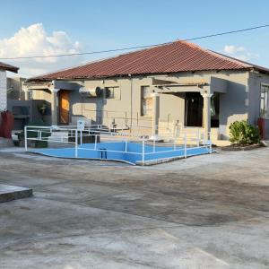 a building with a blue pool in front of it at Godmill guesthouse Taung in Lethola