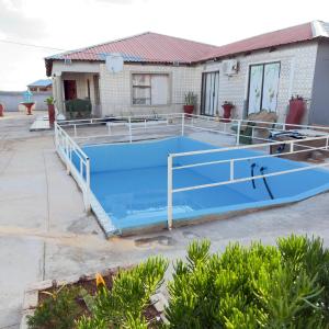 a large blue swimming pool in front of a house at Godmill guesthouse Taung in Lethola