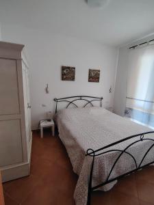a bedroom with a bed in a white room at Casa Ventaglio Verde in Valledoria +13 photos