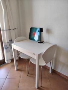 a white desk with a lamp and two chairs at Casa Ventaglio Verde in Valledoria