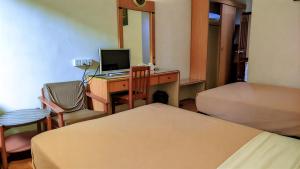 a room with a desk with a computer and a bed at Paradise Hotel in Tanjung Pinang