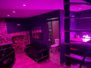 a purple room with a couch and a chair at Spa love room in Donges
