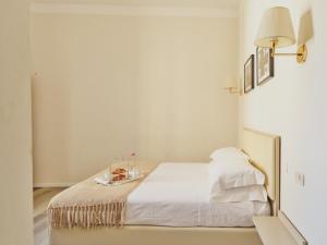 a white bedroom with a bed with a tray on it at Hotel L'Aretino in Arezzo +39 photos