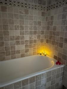 a bathroom with a bath tub with candles in it at Le Petit Paradis in Honfleur +22 photos