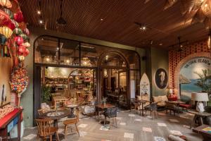 a restaurant with tables and chairs in a room at Tropical Dorm Hostel Da Nang by Haviland in Danang