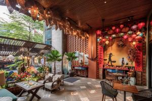 a restaurant with tables and chairs in a room at Tropical Dorm Hostel Da Nang by Haviland in Danang