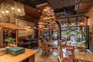 a restaurant with tables and chairs and a dining room at Tropical Dorm Hostel Da Nang by Haviland in Danang