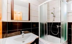 a bathroom with a sink and a shower at Pensiunea Vacanta in Straja