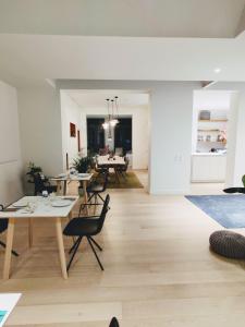 a living room and dining room with tables and chairs at b&b les invités in Bruges