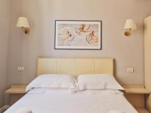 a bedroom with a bed with a picture on the wall at Hotel L'Aretino in Arezzo