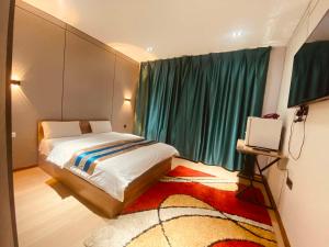 a bedroom with a bed and a window with a television at Ayanchin Hotel in Ulaanbaatar