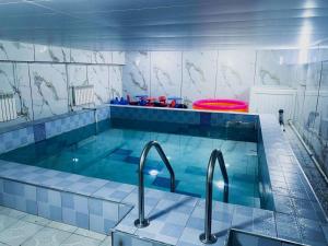 a swimming pool with two faucets and a red frisbee at Ayanchin Hotel in Ulaanbaatar