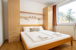 a bedroom with a large white bed with a window at Apartmentdorf Flößerstube in Grossraming
