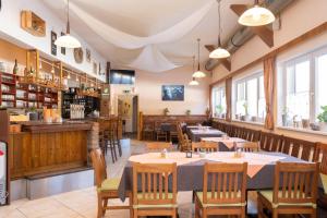 a restaurant with tables and chairs and a bar at Apartmentdorf Flößerstube in Grossraming