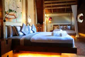 een slaapkamer met een groot bed en handdoeken bij Kaleydo Villas in Gili Trawangan
