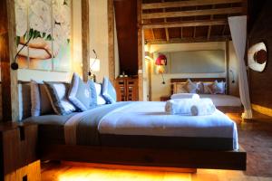 a bedroom with a large bed with towels on it at Kaleydo Villas in Gili Trawangan