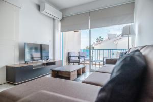 a living room with a couch and a tv at Beach Escape Beachfront Apartment in Pyla