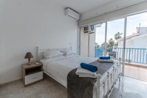 a bedroom with a large bed and a balcony at Beach Escape Beachfront Apartment in Pyla