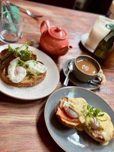 a table with two plates of food and a cup of coffee at The Ivy House in Chalfont Saint Giles