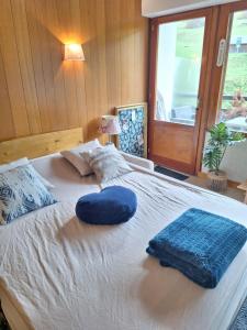 a large white bed with two pillows on it at Le Ptit Beau Jus in Aillon-le-Jeune