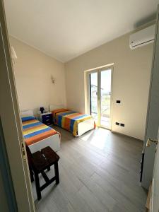 a room with two beds and a window at Casa Decastadio in Melito di Porto Salvo