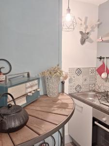 a kitchen with a wooden table and a sink at Le Ptit Beau Jus in Aillon-le-Jeune