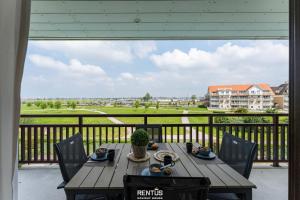 a table on a balcony with a view of a golf course at Seange - with beautiful view and many facilities in Nieuwpoort