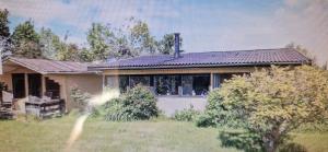 a house with a large window in a yard at Bogø feriehus in Bogø By
