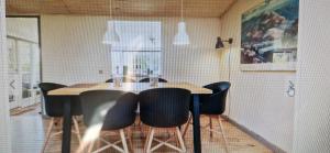 a dining room with a table and black chairs at Bogø feriehus in Bogø By