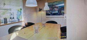 a wooden table with two glasses on top of it at Bogø feriehus in Bogø By
