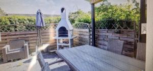 a patio with a table and a chair and an umbrella at Bogø feriehus in Bogø By +4 photos