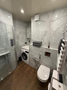 a bathroom with a toilet and a washing machine at BRIVIBAS RESIDENCE - WAVE, free PRIVATE parking, free WIFI, self check-in in Riga