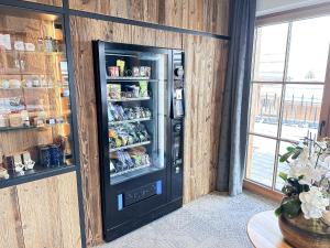 a black refrigerator in a room with food inside at ZAGLGUT Premium Hotel & Chalets, Zell am See-Kaprun - Wellness & Infinity Pool, Air Conditioning, Panoramic Views & Summer Card Included in Kaprun