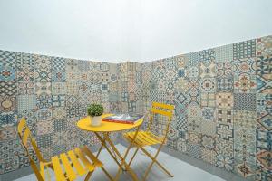 a table and two chairs in a room with tiles at Hôtel Edgar Quinet in Paris