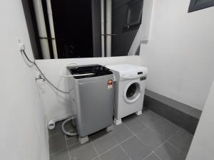 a washer and dryer in a small bathroom at Halimah Guesthouse in Putatan