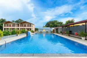 a large swimming pool with blue water in front of a building at Milestone Resort in Thūr