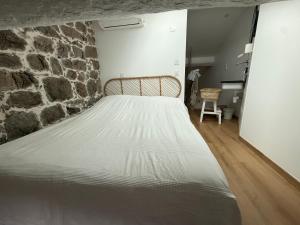 a large bed in a room with a stone wall at Casa Tassinca in Tasso