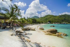 a beach with rocks and palm trees and the ocean at Crystal Bay Yacht Club Beach Resort in Lamai