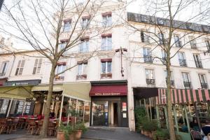 a building on a city street with tables and chairs at Hôtel Edgar Quinet in Paris