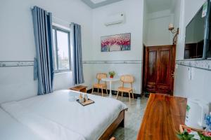a bedroom with a bed and a table with chairs at Jayden Hotel - Phú Quý in Îlot du Sud