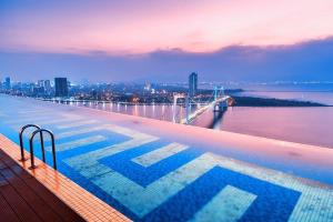 a swimming pool on top of a building with a view of the water at Golden Bay Danang in Danang