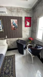 a bedroom with a bed and two chairs and a table at Jumeaux Studio in Luanda