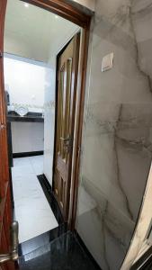 a bathroom with a walk in shower next to a mirror at Jumeaux Studio in Luanda