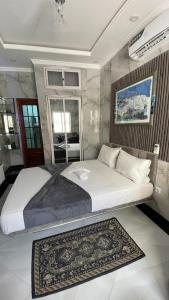 a bedroom with a large bed with a rug at Jumeaux Studio in Luanda