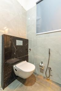 a bathroom with a white toilet in a room at Milestone Resort in Thūr +17 photos